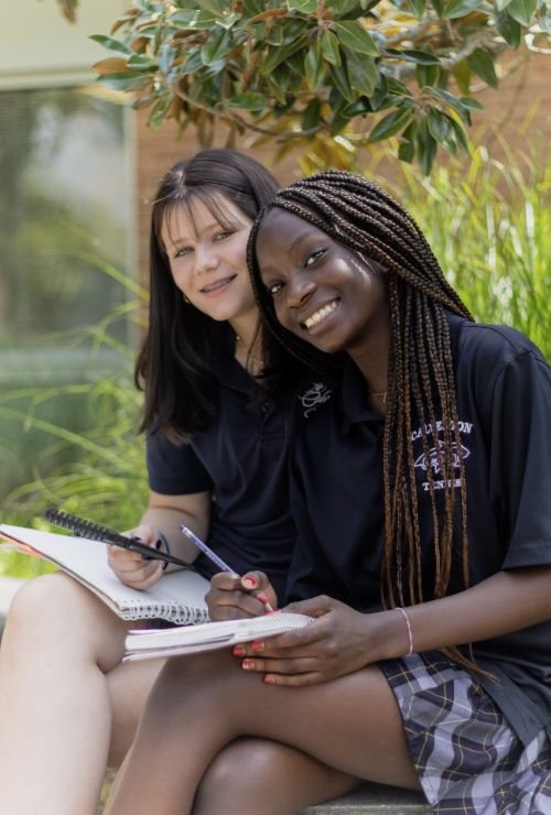 two female students sitting outside