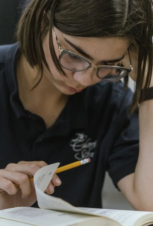 female student researching in textbook