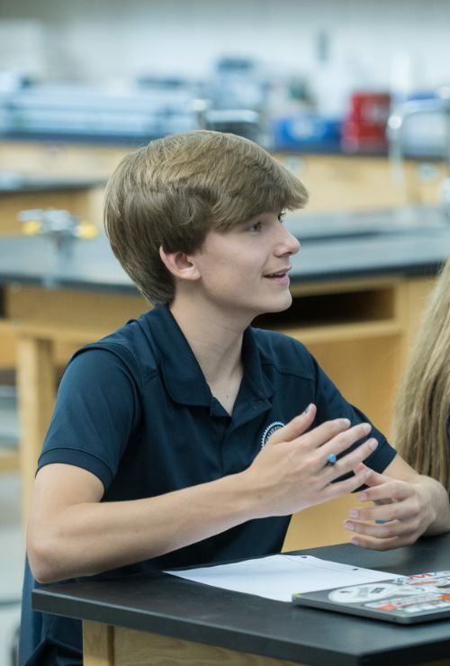 student at desk in science classroom