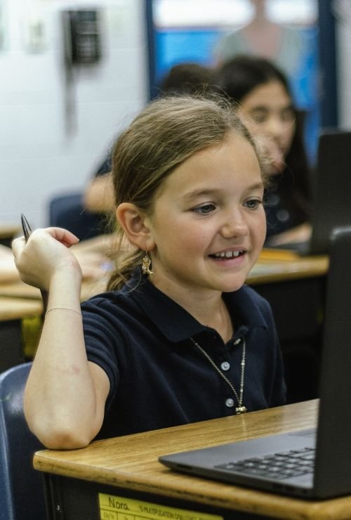 lower school student in class working on laptop