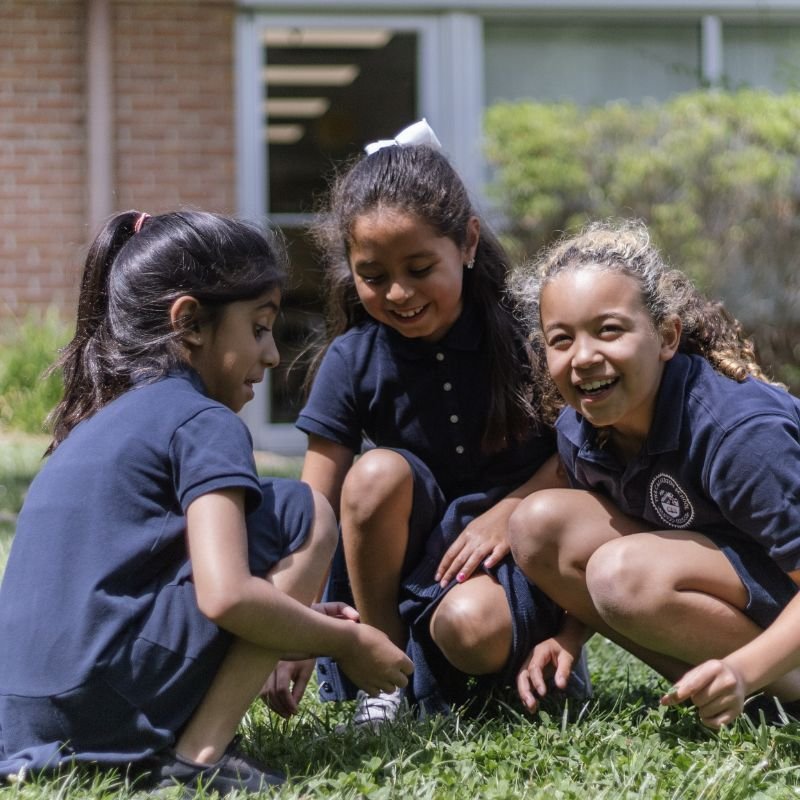 lower school students outside playing in the grass